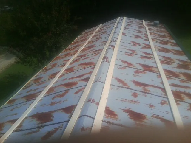 Rusted metal roof panels with new wood purlins before replacement — Storm Damage Roof Repair in Ether by Roofing Brothers