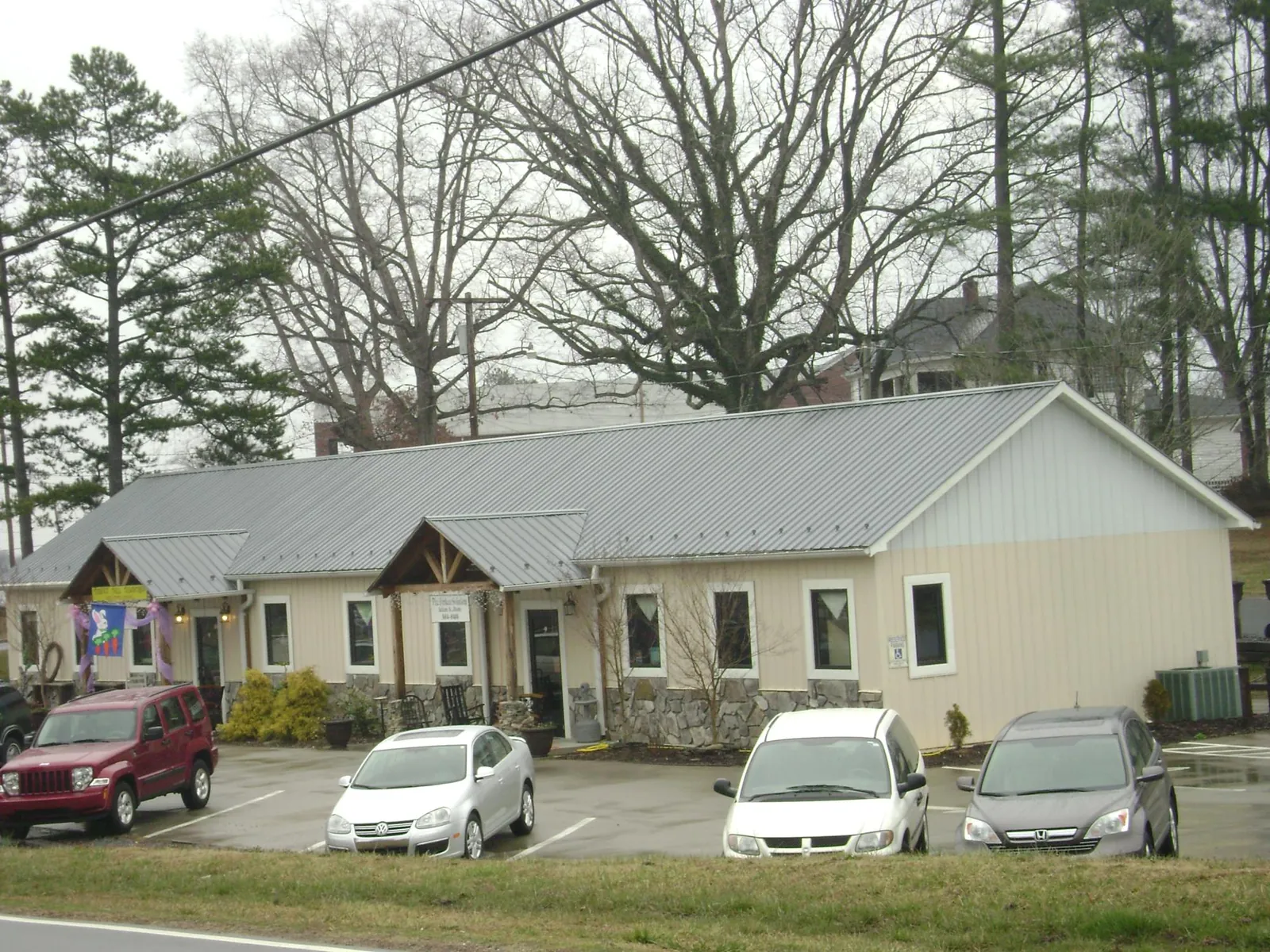 Gray metal roof with timber entry brackets on a small commercial building in Ether