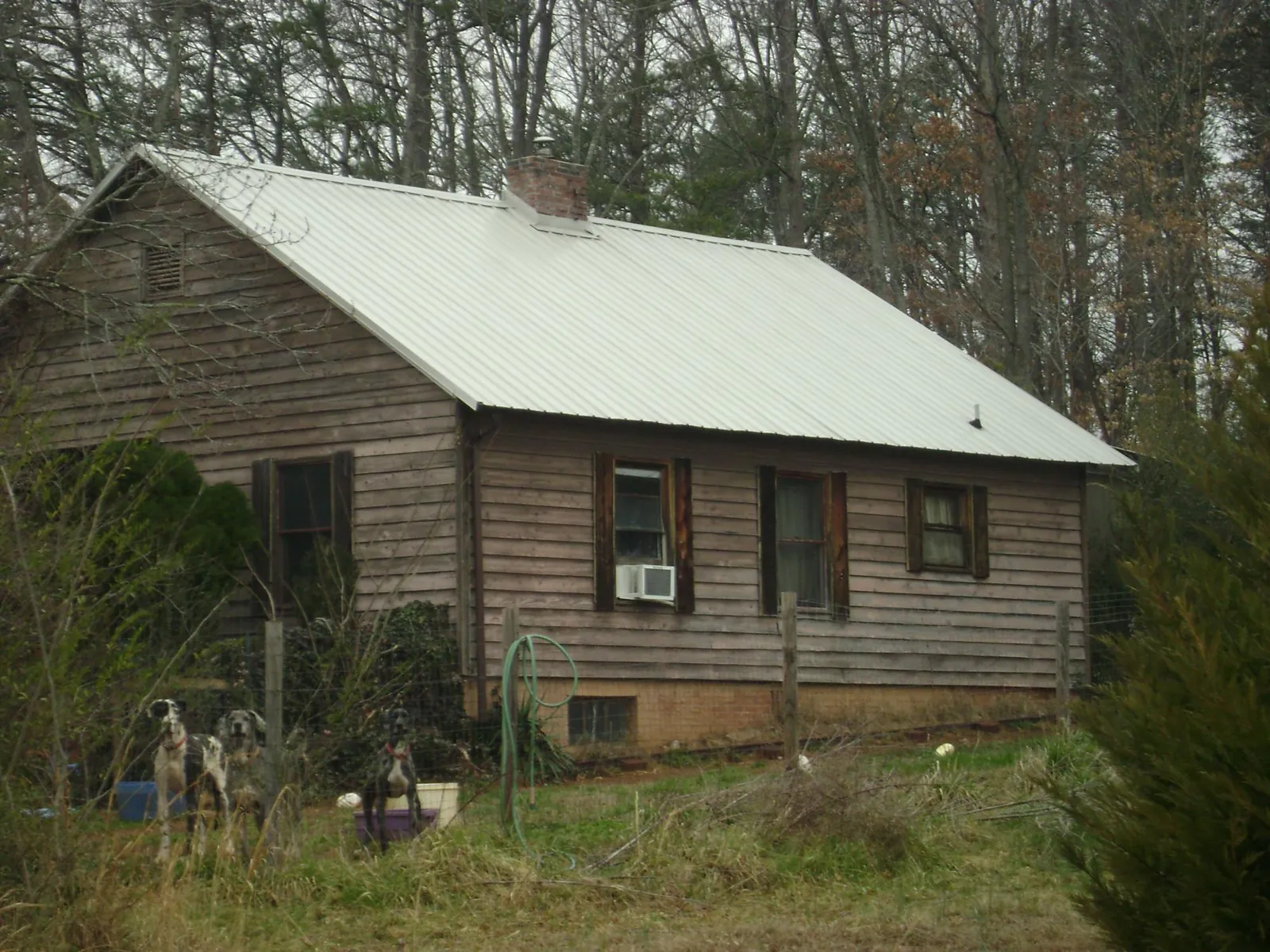 White metal roof on an old wood sided farmhouse, from a Metal Roof Installation job in Ether